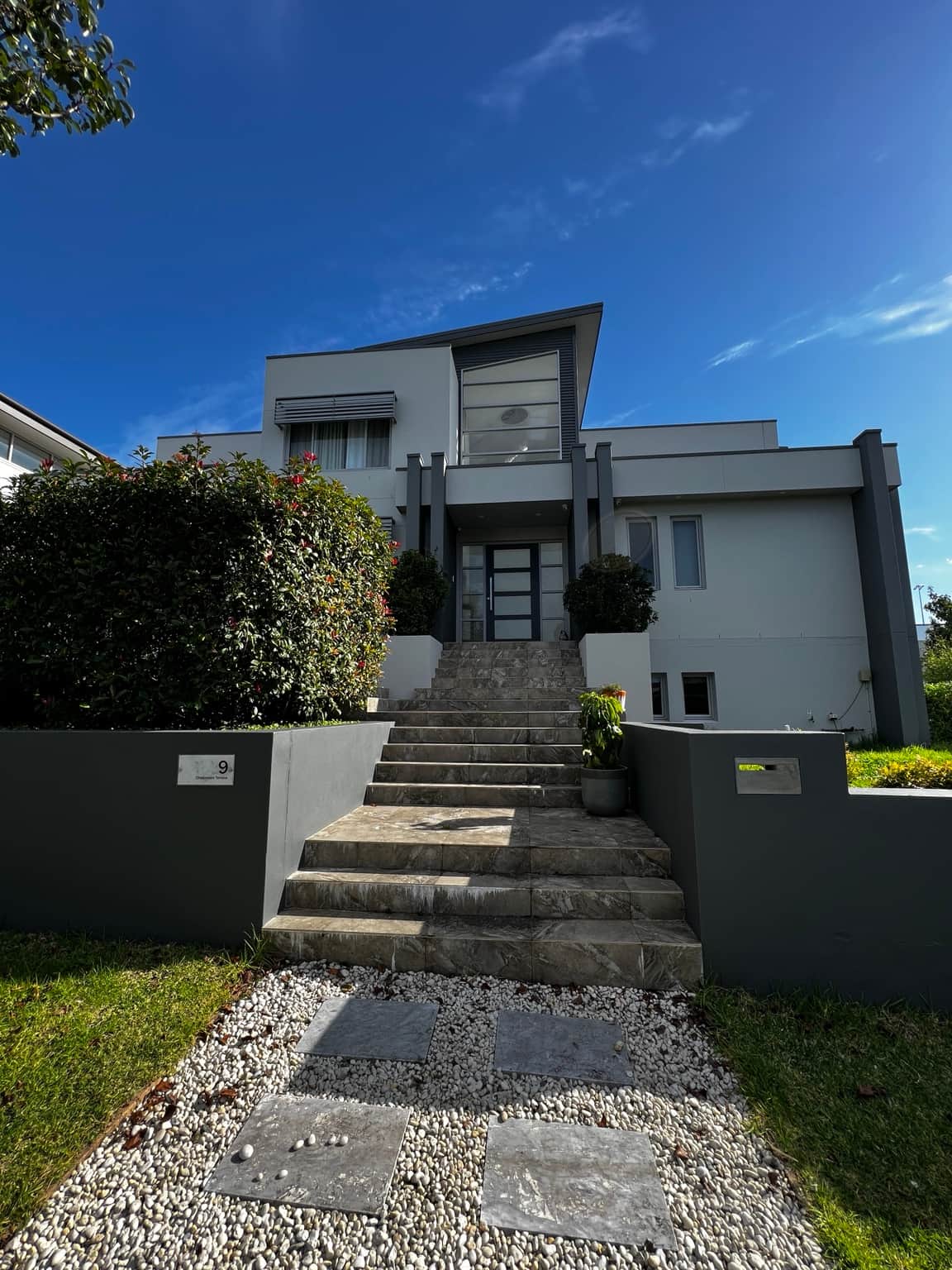 Grey and white exterior facade above the front entrance steps at a Bella Vista home
