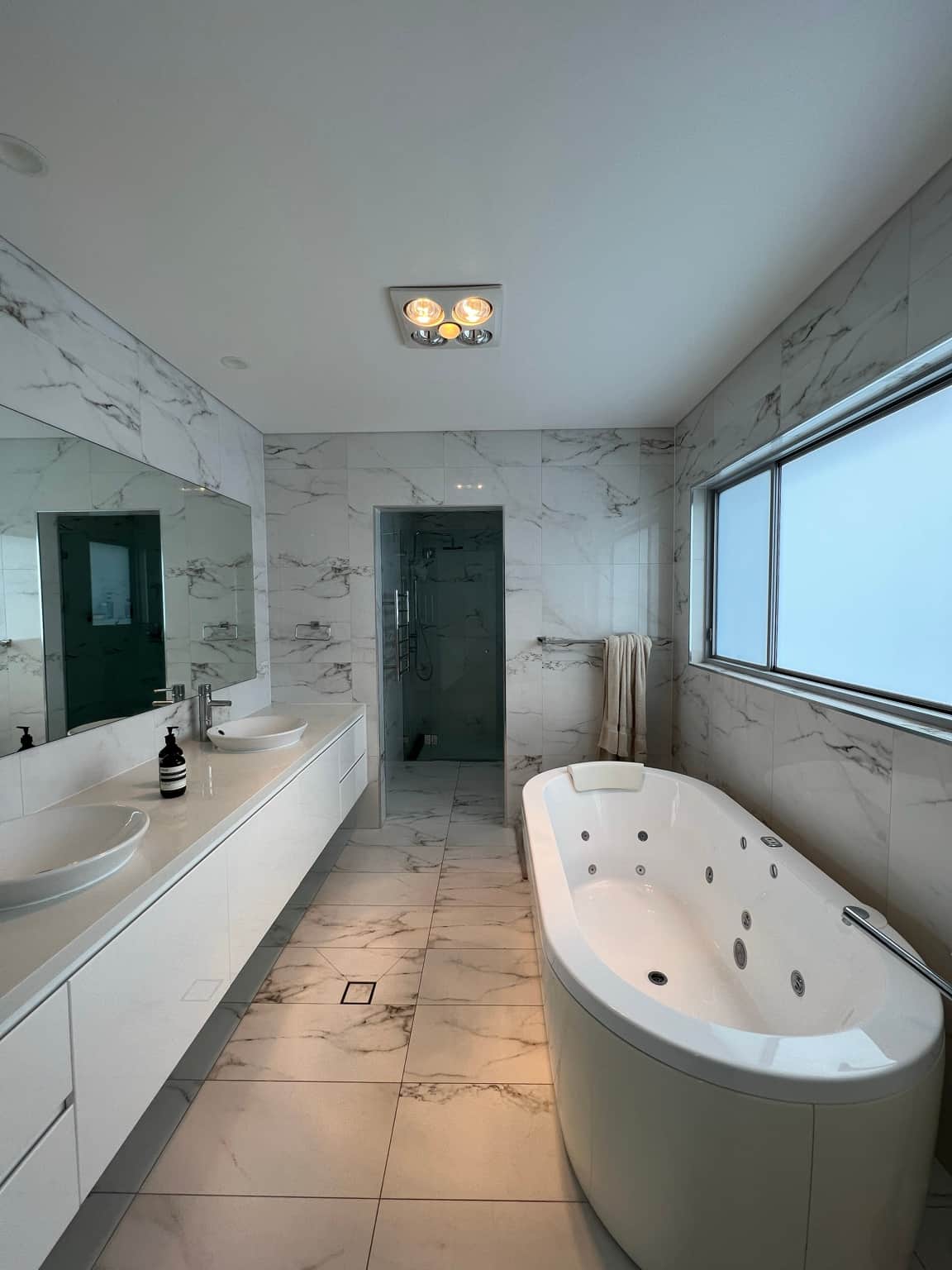 Bathroom ceiling and window surround above marble-look wall tiles