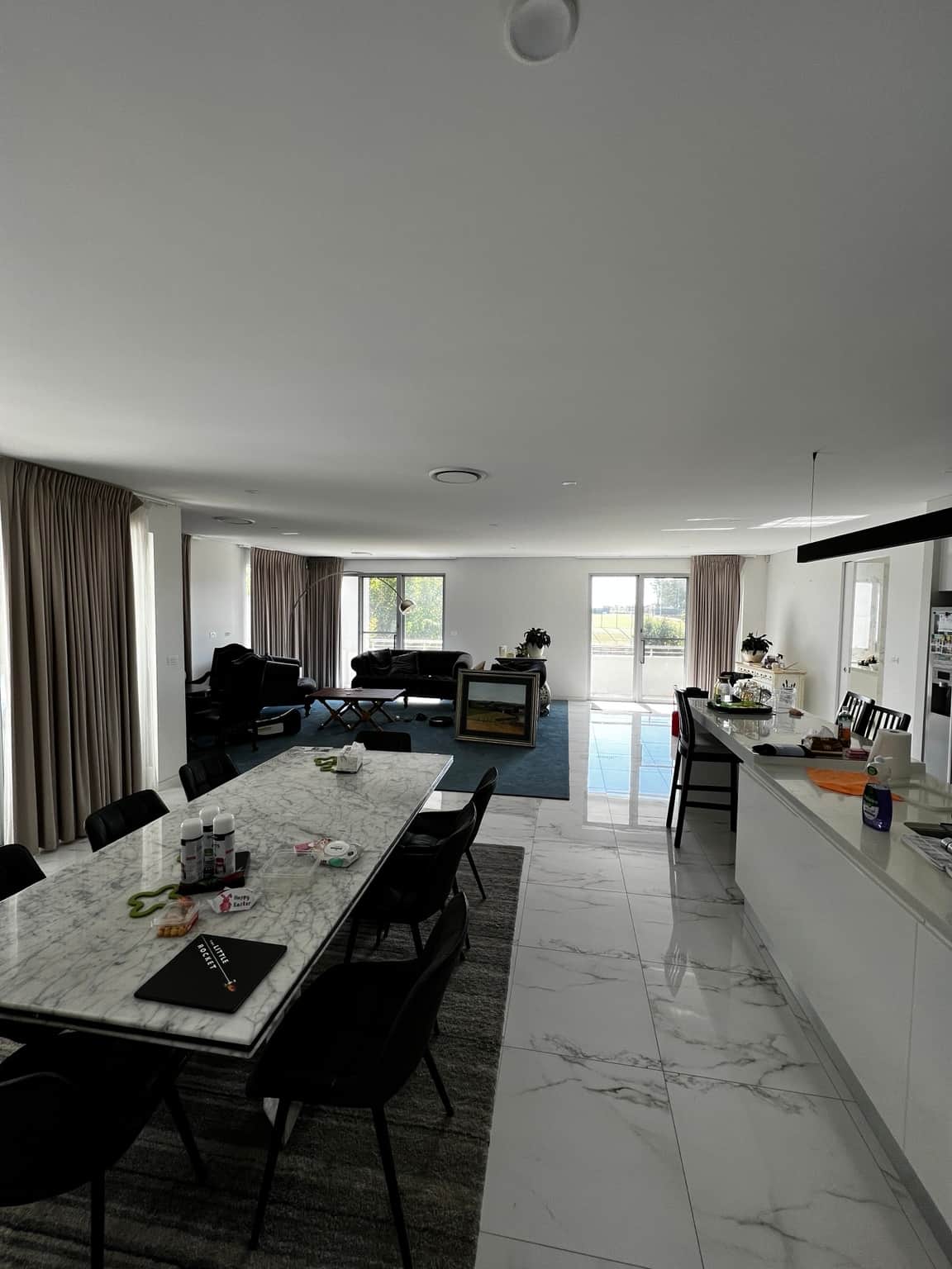 Open-plan dining and living room with white walls and ceiling in Bella Vista