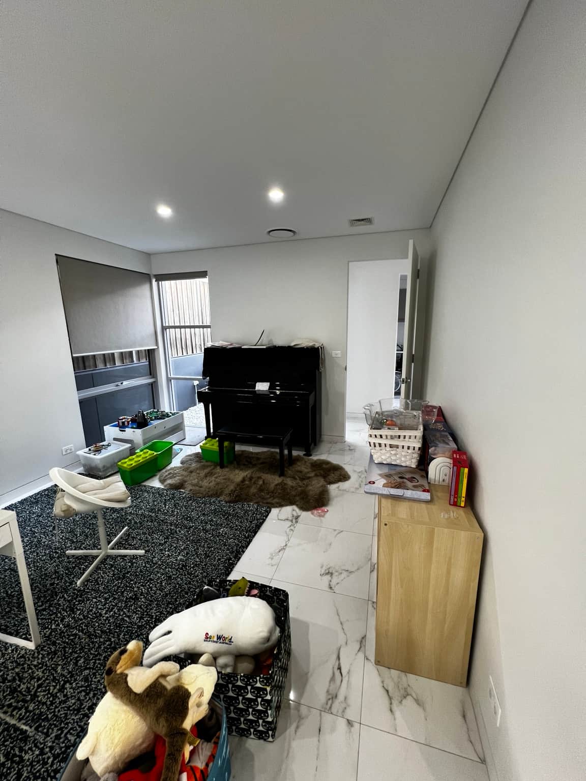 Kitchen and adjoining lounge with light walls and flat ceiling