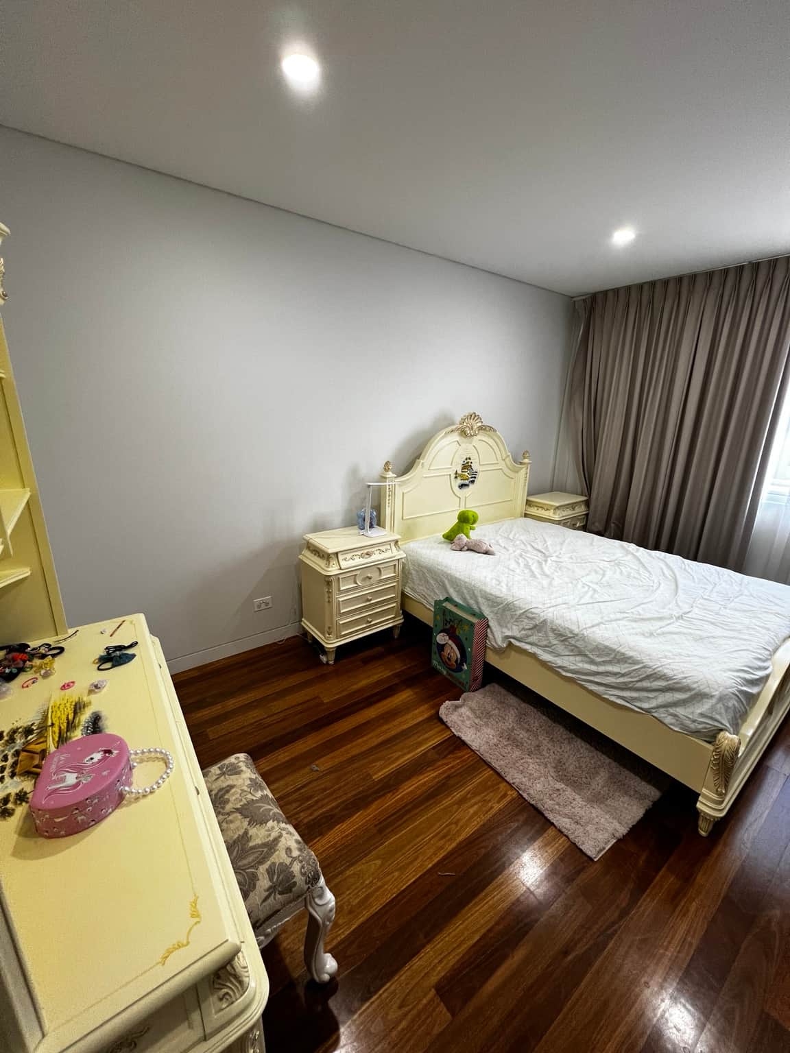 Light bedroom walls and ceiling with timber floor and curtains