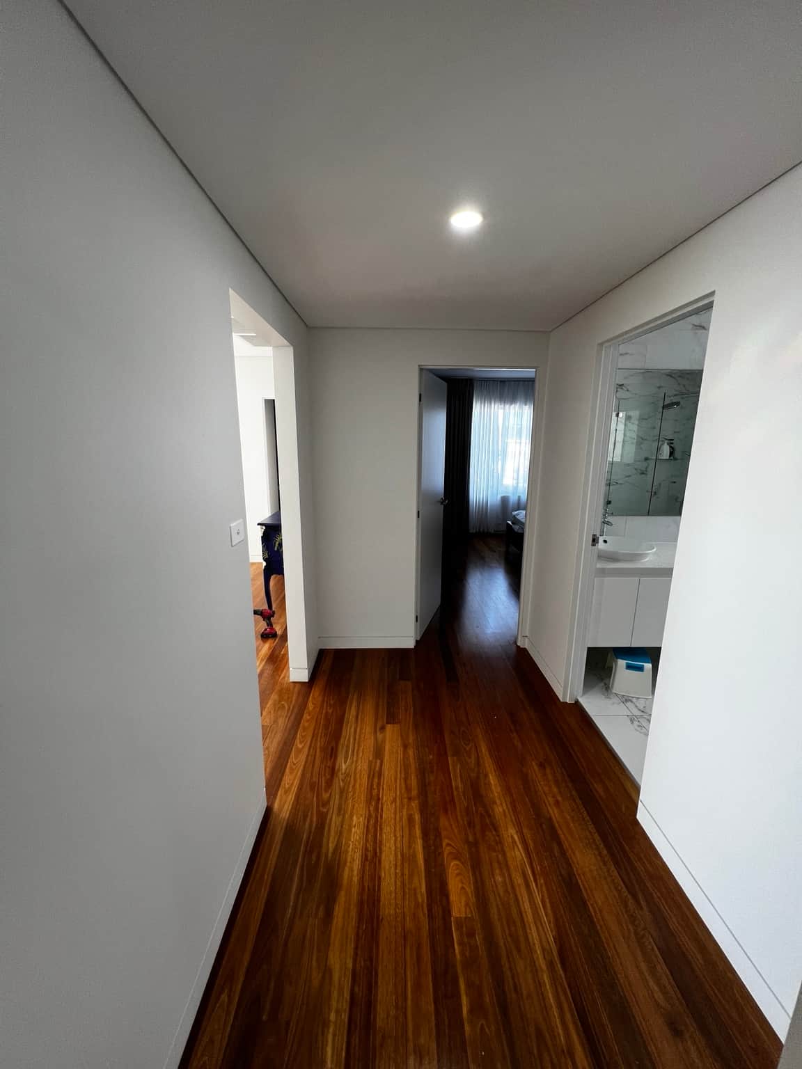 Painted bedroom entry and adjoining hallway above timber flooring
