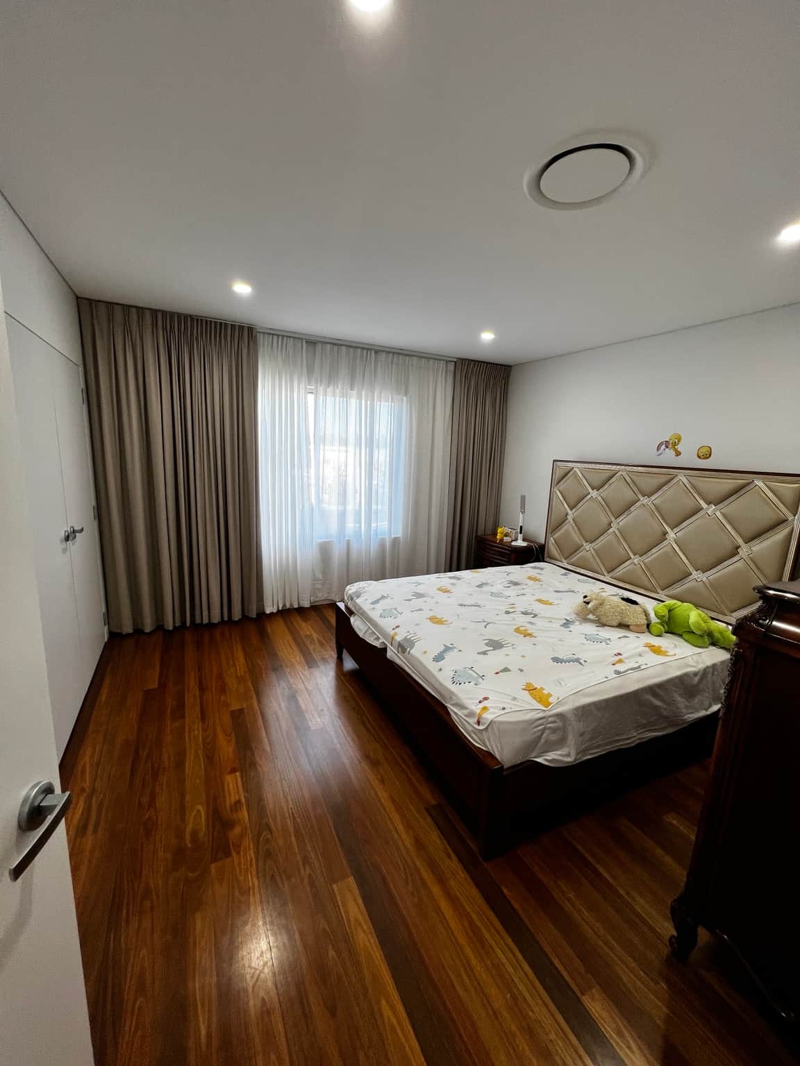Bedroom wall and ceiling finishes beside full-height curtains