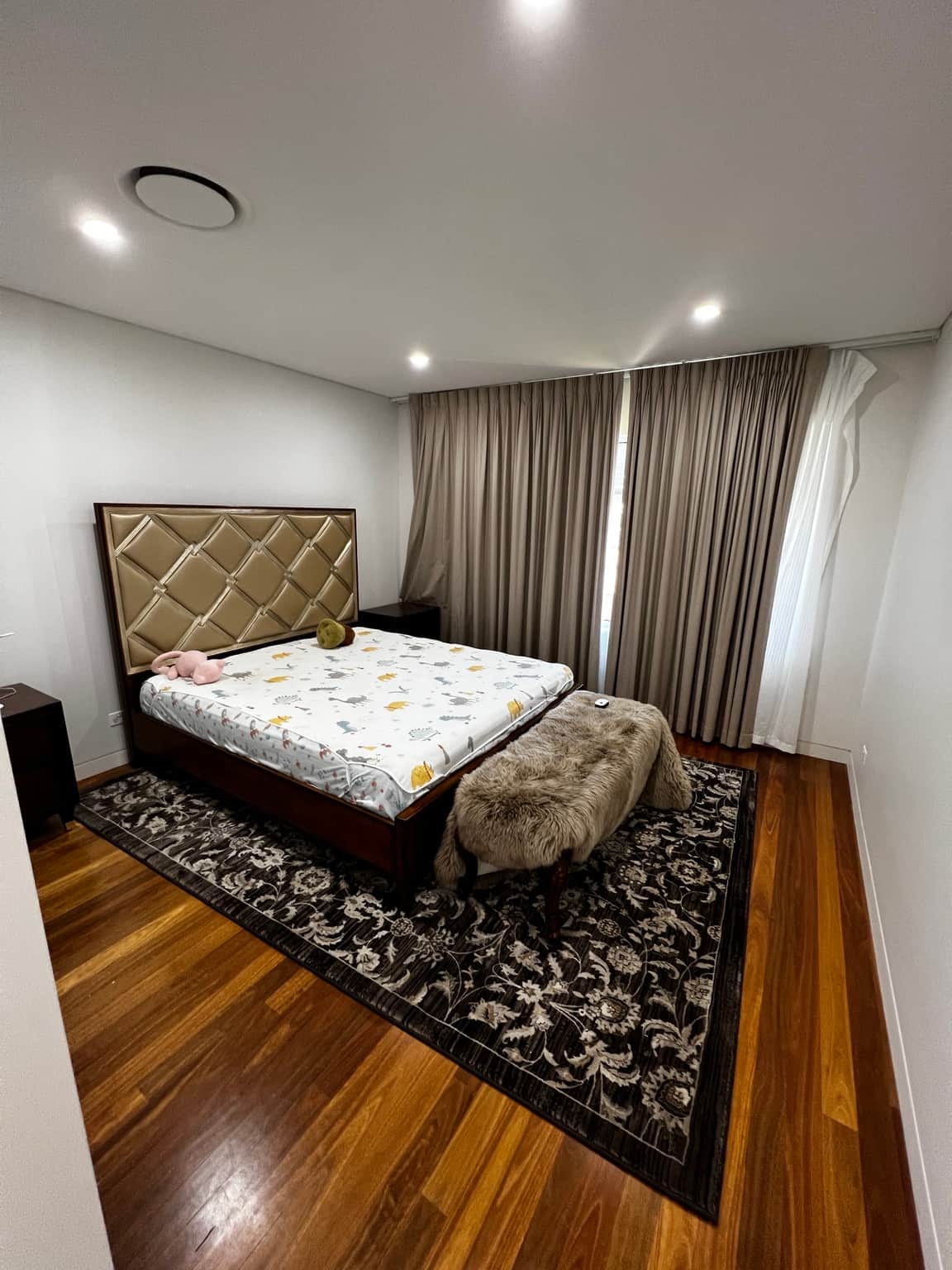 Bedroom with light painted walls and flat ceiling above timber flooring