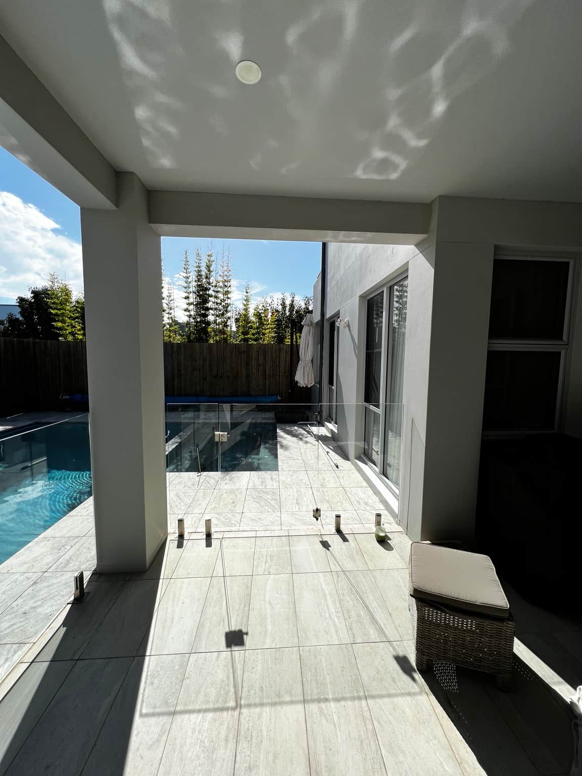 White patio ceiling and grey columns beside the swimming pool at a Bella Vista home