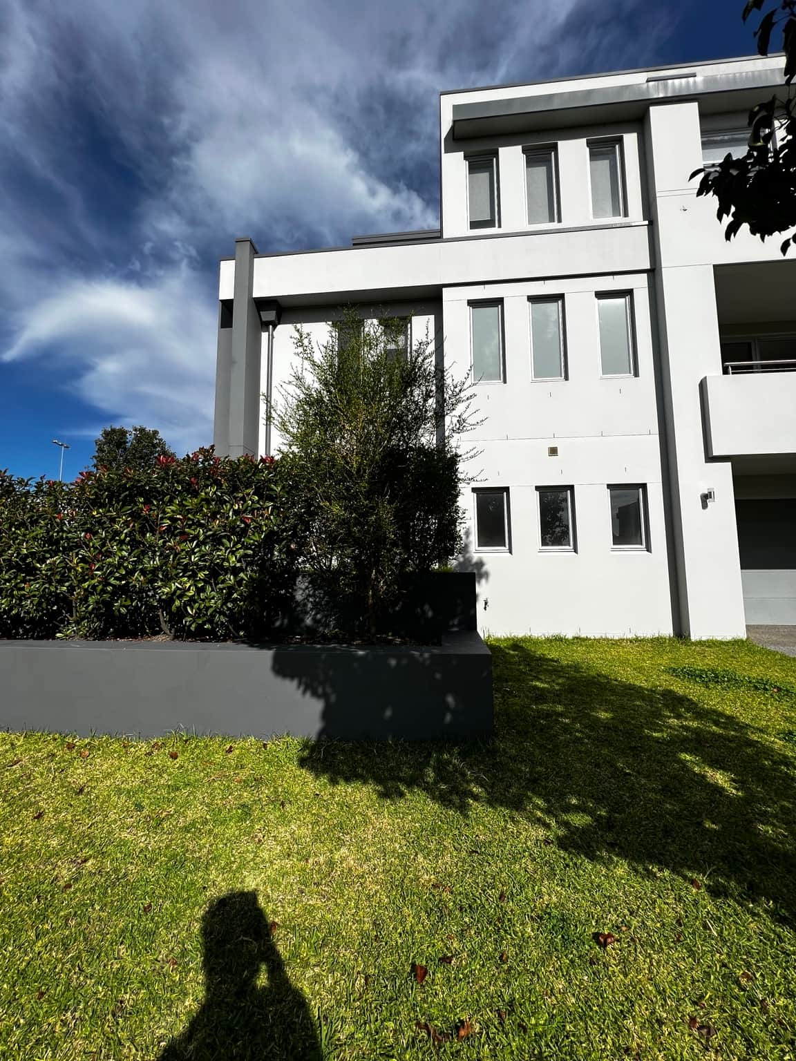 White rendered facade with tall windows and grey trim after exterior painting in Bella Vista