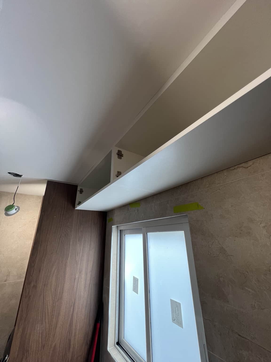 Painted bathroom ceiling above the window and cabinets in Bexley