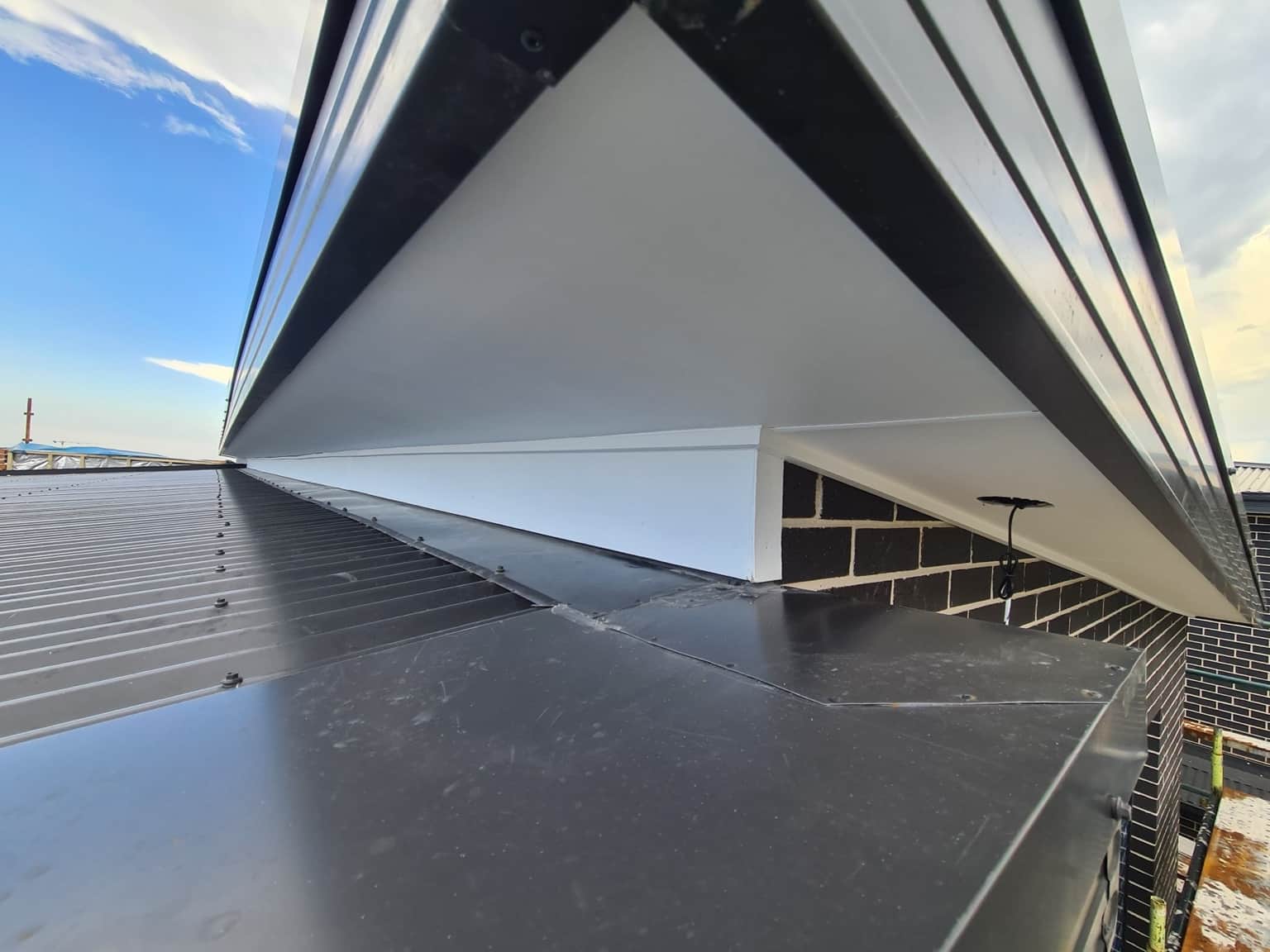 Painted gable and soffit beside the dark roofline of the Box Hill new build