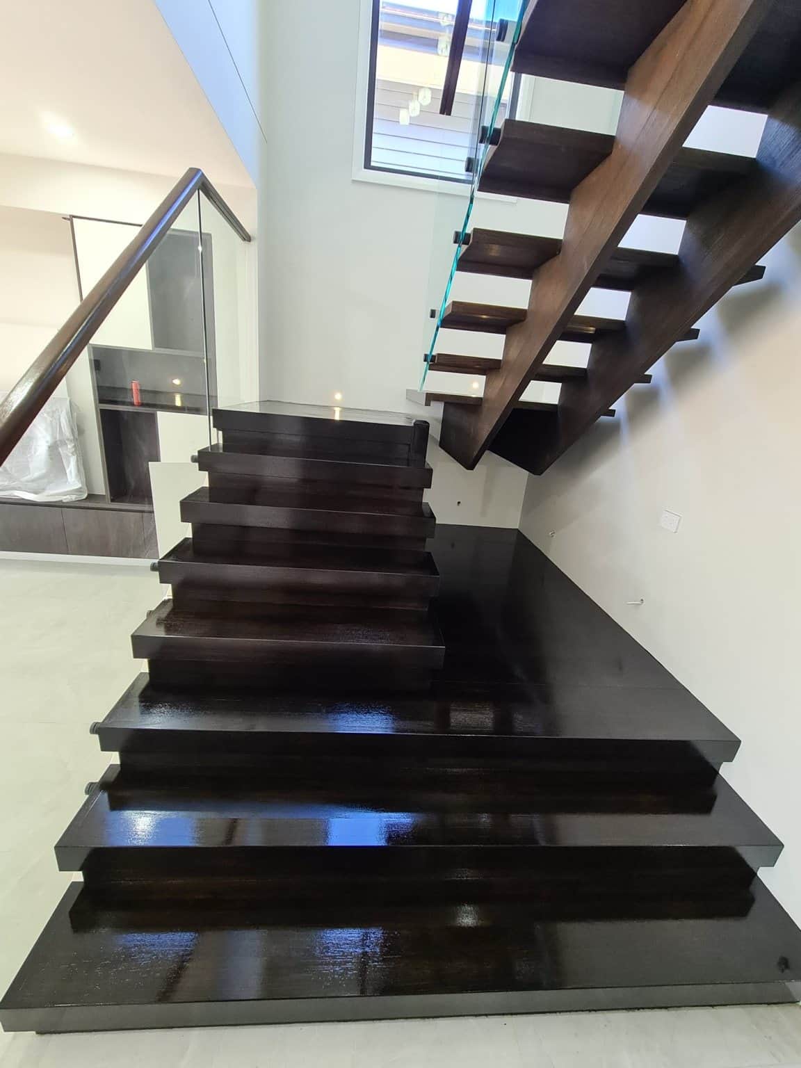 Box Hill timber staircase after Feast Watson stain and clear coat, with dark treads and glass balustrades.