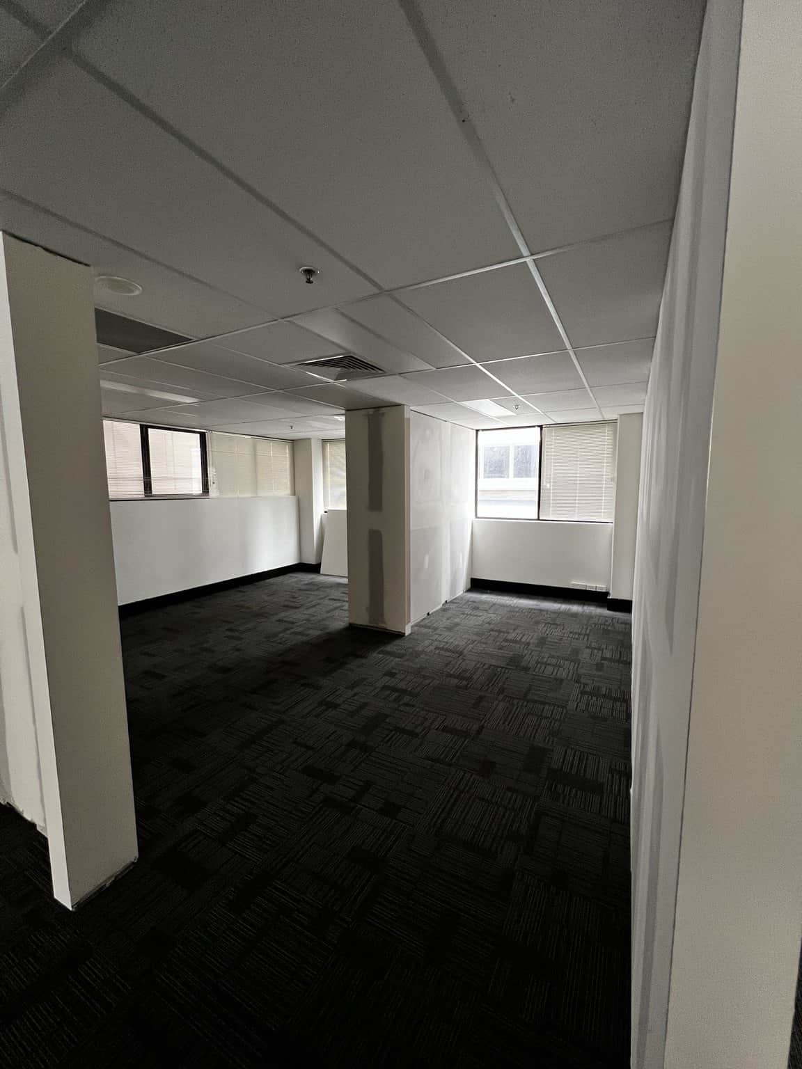 Connecting office spaces in Chatswood with prepared walls and dark carpet tiles.
