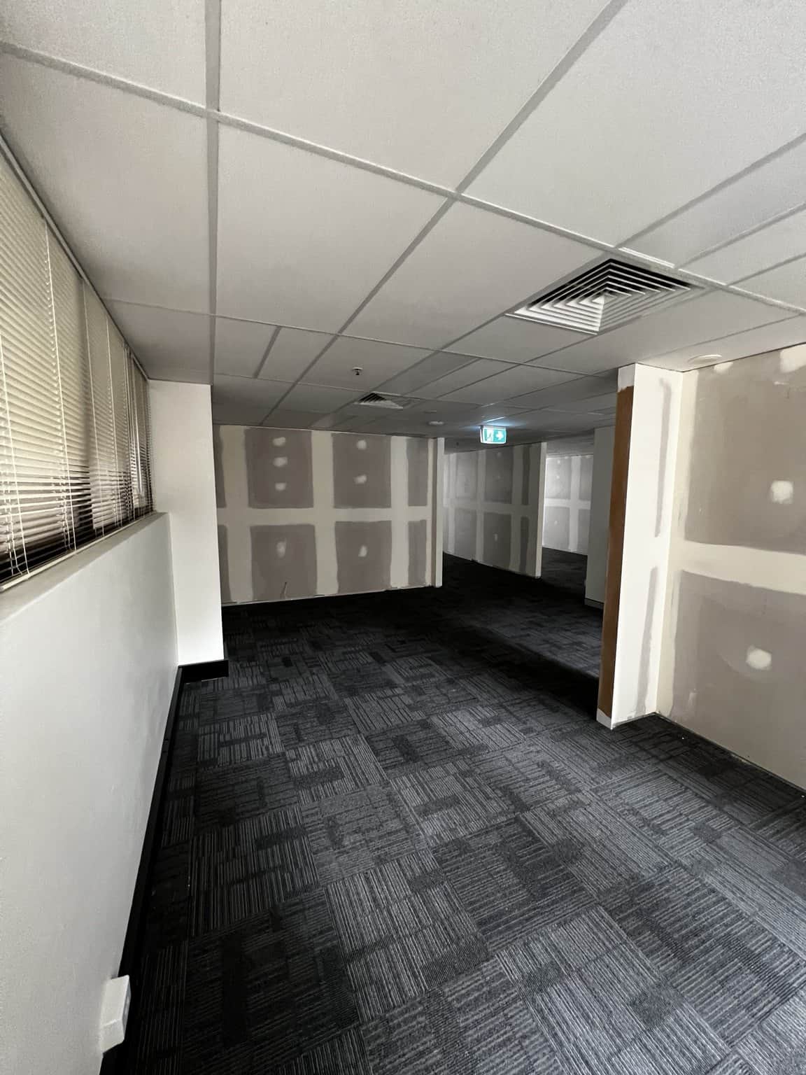 Wall preparation beside the corridor and exit area of a Chatswood office.