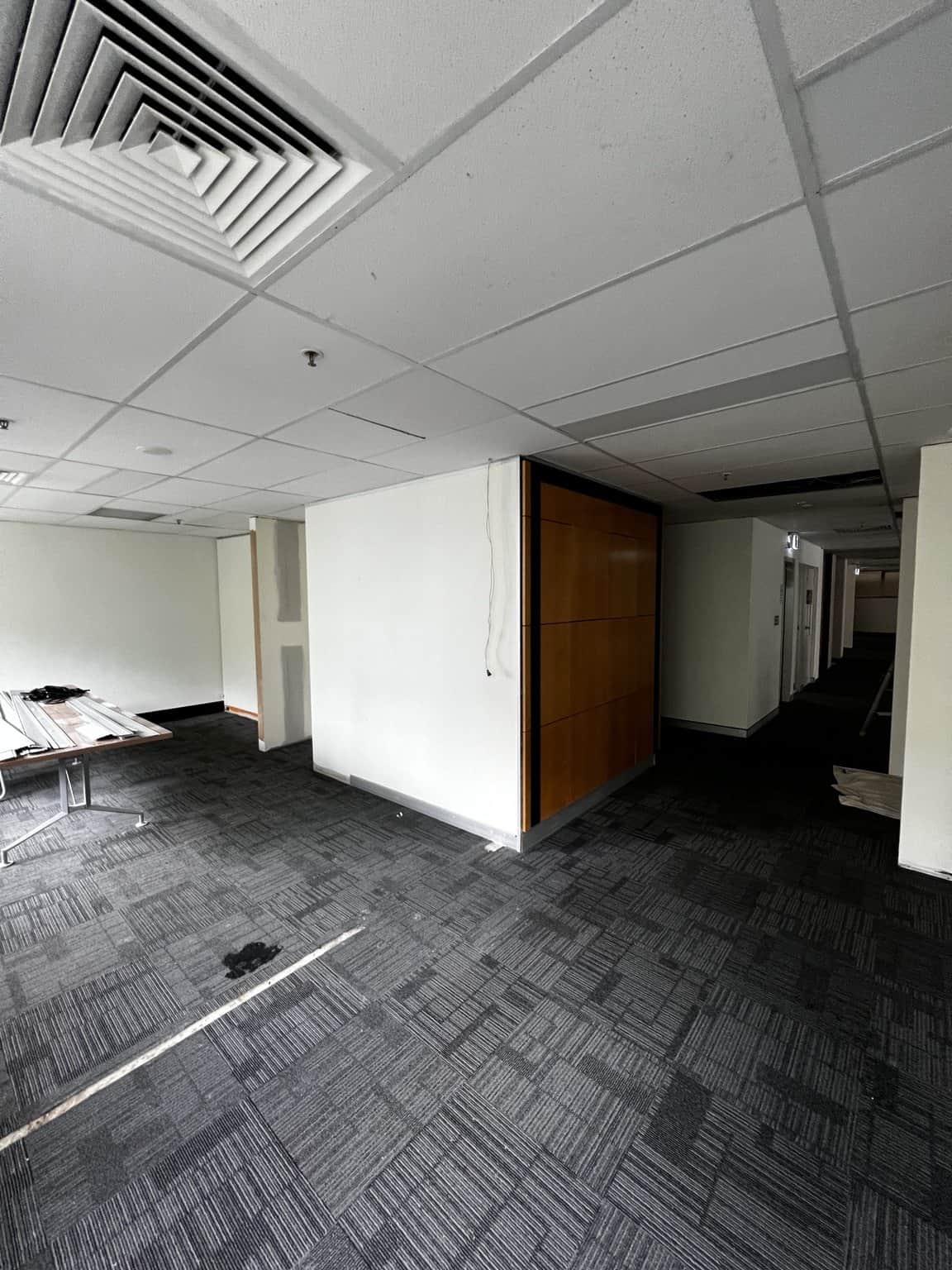 Chatswood office walls being prepared around a timber doorway beside dark carpet tiles.