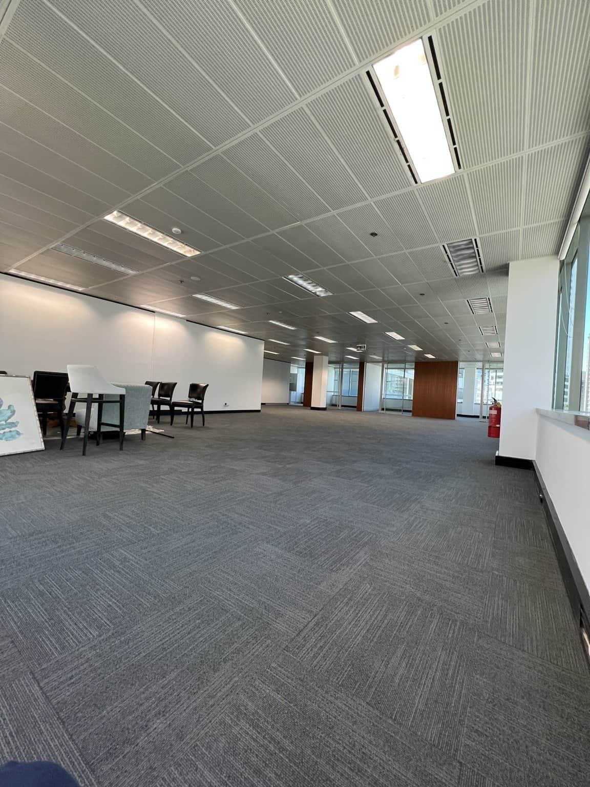 Open-plan Chatswood office with light walls, grey carpet and meeting furniture.