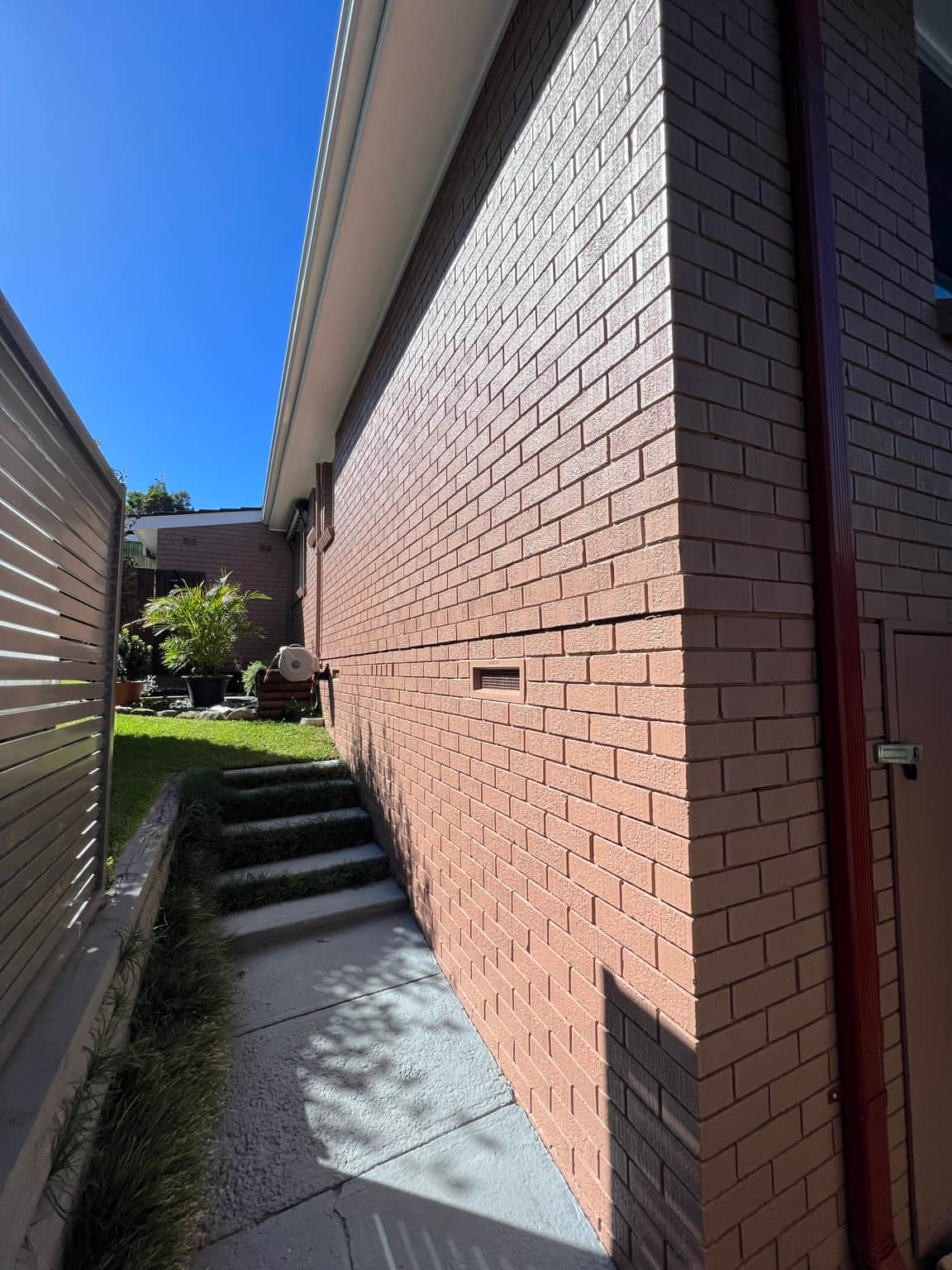 Finished exterior brick wall along the side passage in Cowan