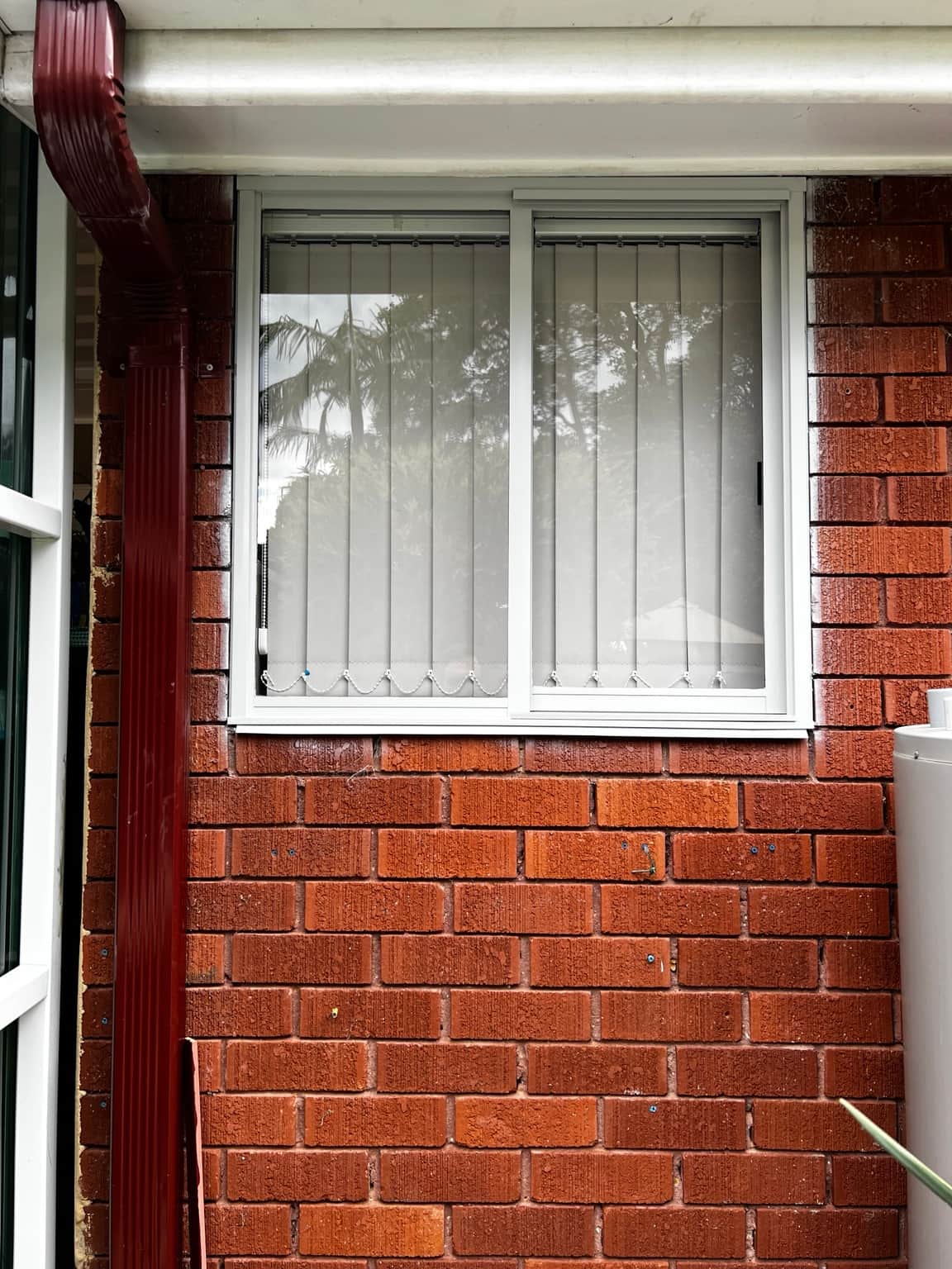 Painted aluminium window above original red brickwork in Cowan