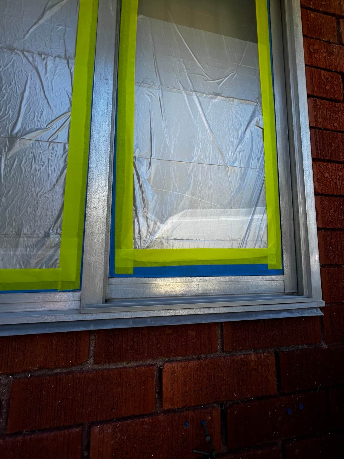 Window glass protected with masking during spray painting in Cowan