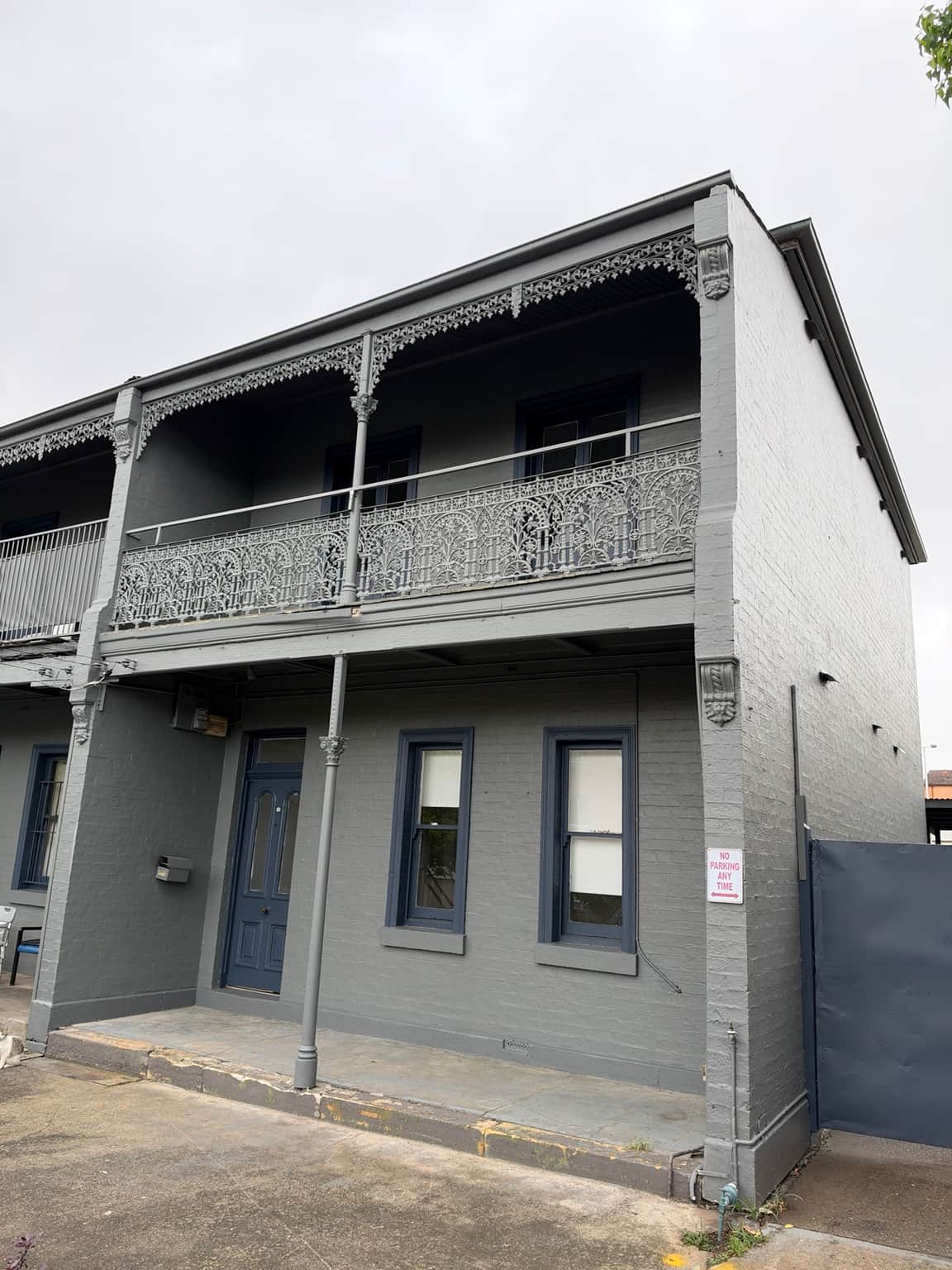 Grey front facade, balcony and decorative ironwork after exterior painting in Granville
