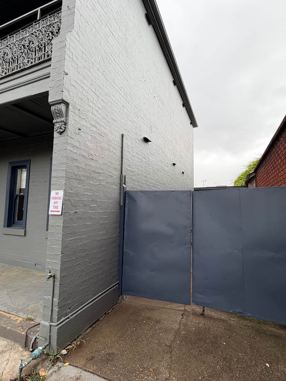 Painted grey side wall and dark gate at the Granville exterior repainting project