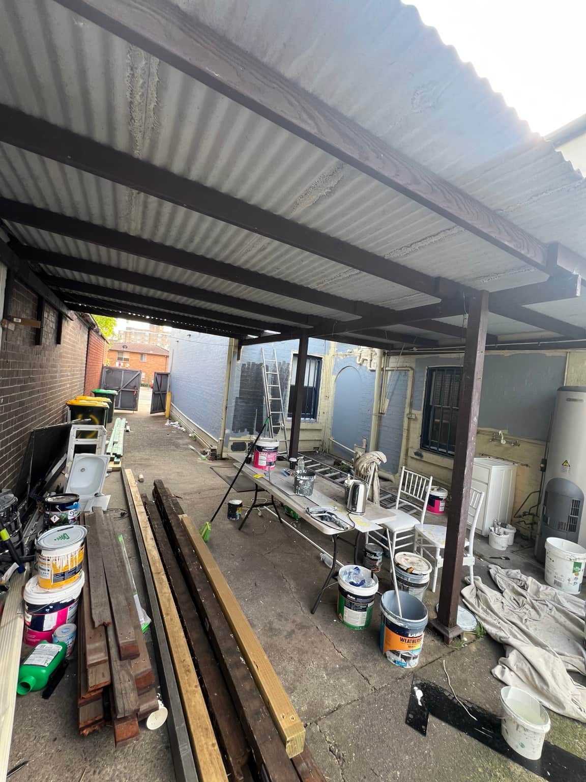 Rear covered outdoor area before exterior painting at the Granville property
