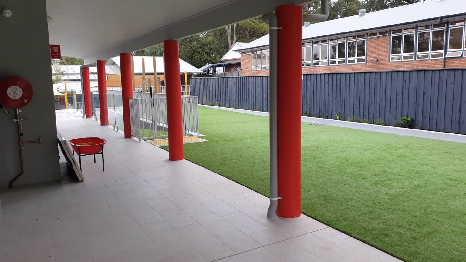 Completed outdoor area with painted timber fence and covered walkway in Hornsby