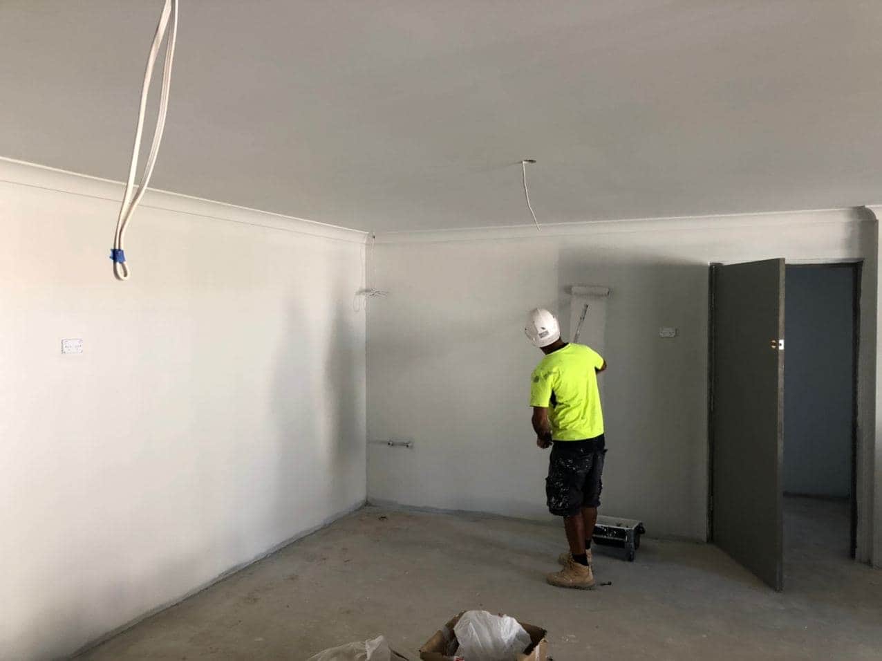 Painter applying paint to an interior wall during the Hornsby childcare build