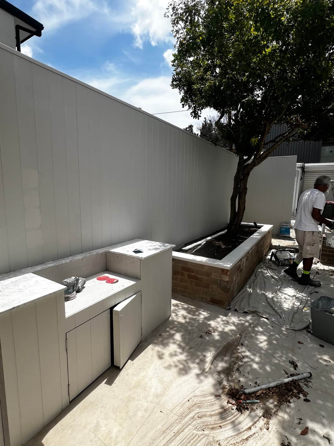 Newtown courtyard wall beside outdoor cabinets and a raised garden planter