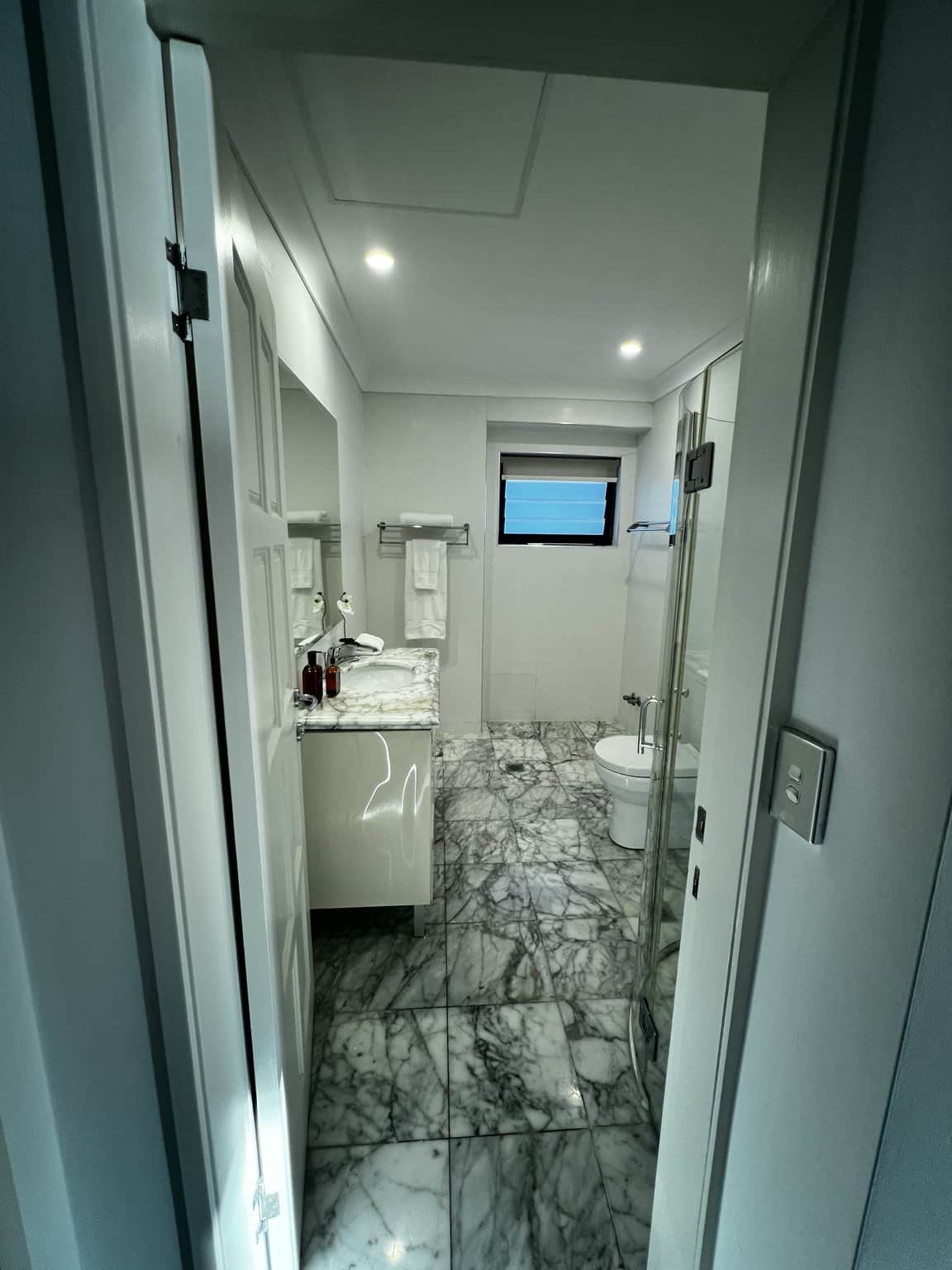 View through a Northbridge bathroom doorway towards the light ceiling and tiled interior.