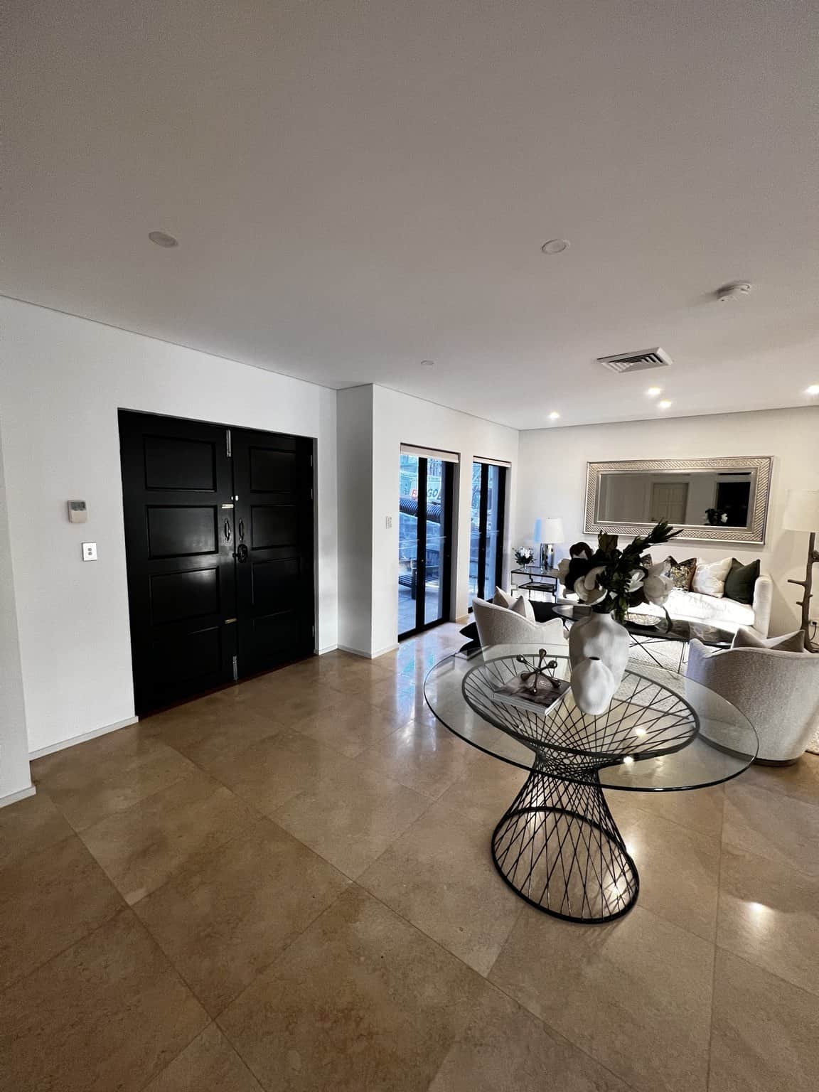 Northbridge entrance hall with light painted walls, recessed lights and a floral display.