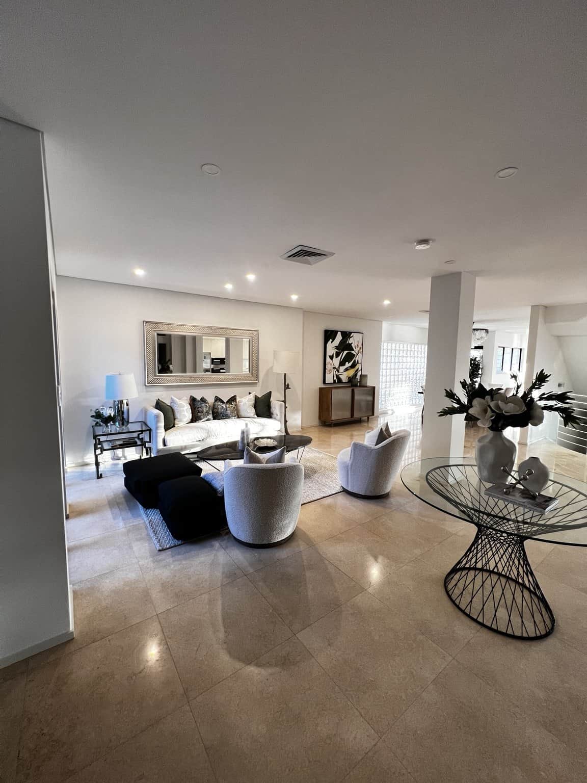 Northbridge formal lounge with light painted walls, white seating and a wall mirror.
