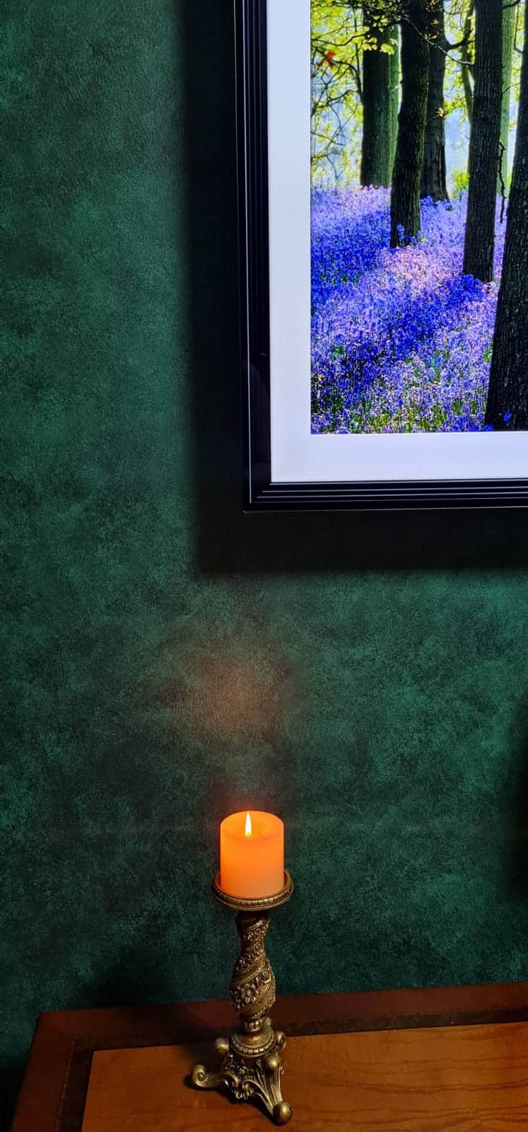 Close-up of green French Wash colour variation beside framed artwork and a candle