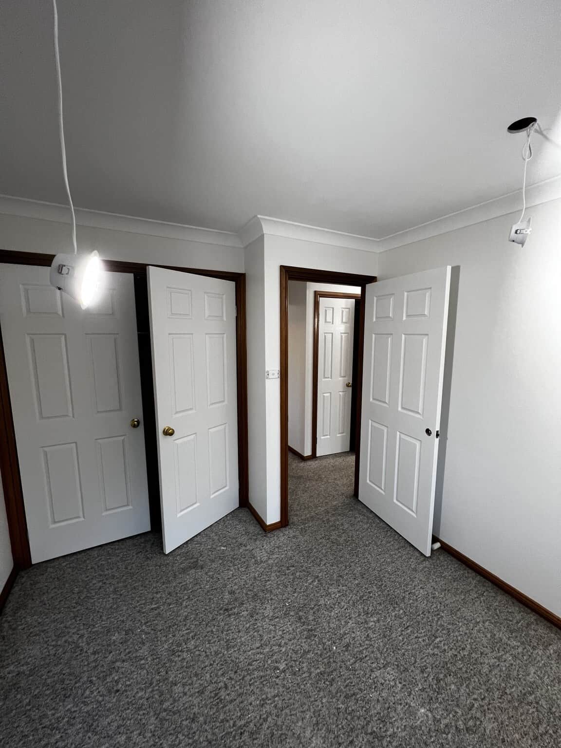 Bedroom and wardrobe doors finished in Natural White Quarter Aquanamel, framed by dark timber.