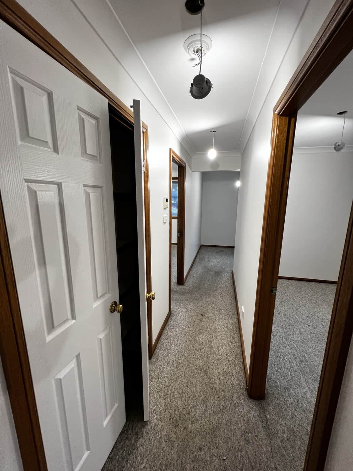 Repainted hallway with open Natural White Quarter doors and retained timber door frames.
