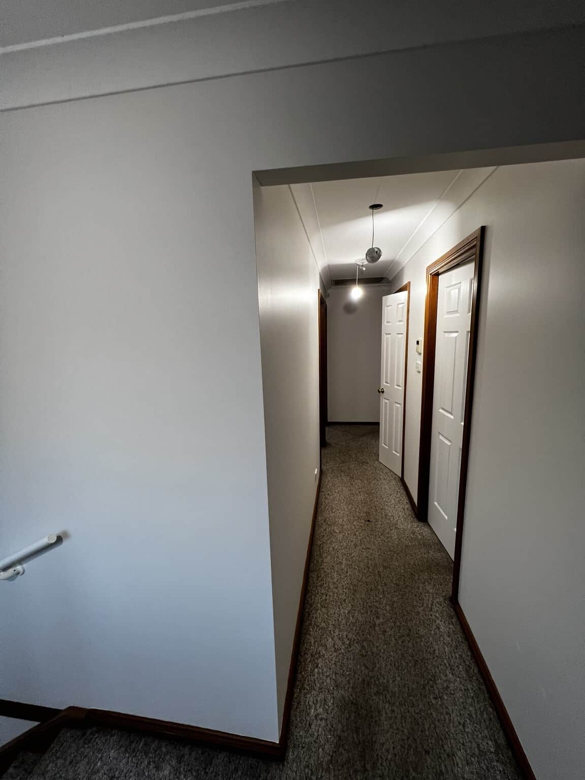 Upstairs hallway in St Marys with Natural White walls, painted doors and carpeted flooring.