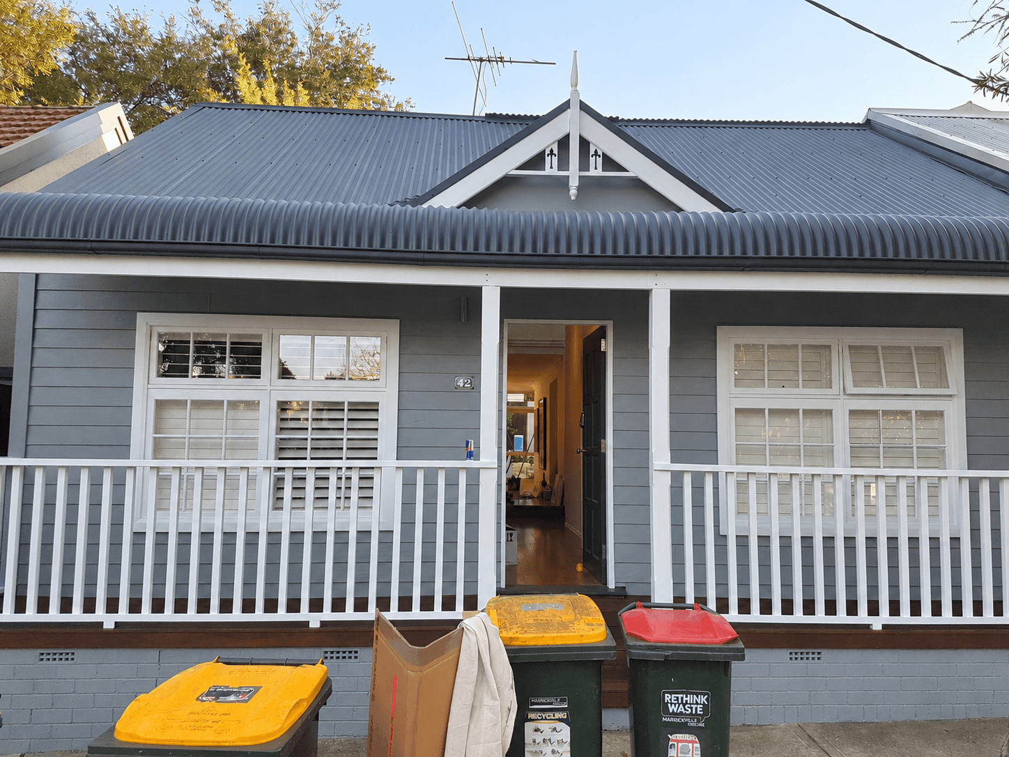 Painted corrugated metal roof, grey weatherboards and white verandah trim in Stanmore