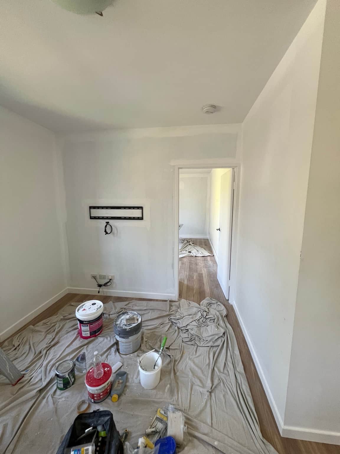 Living room TV wall during painting in Wahroonga, with edge cutting-in and floors protected