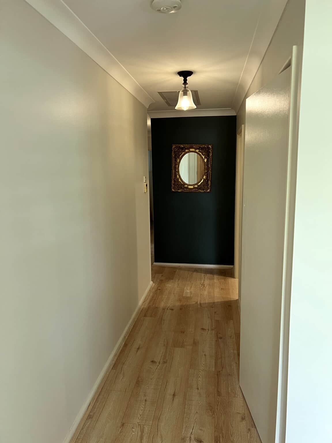 Freshly painted Winston Hills hallway with neutral walls and a deep green Taubmans Endure feature wall.