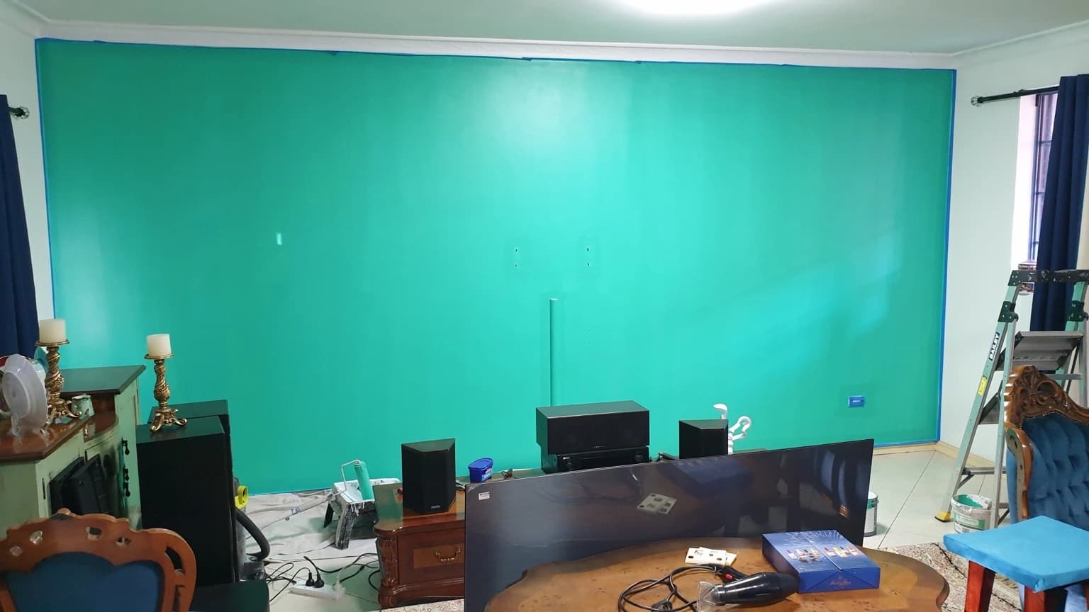 Completed teal and green Porter’s French Wash feature wall behind the television in a Merrylands living room, before