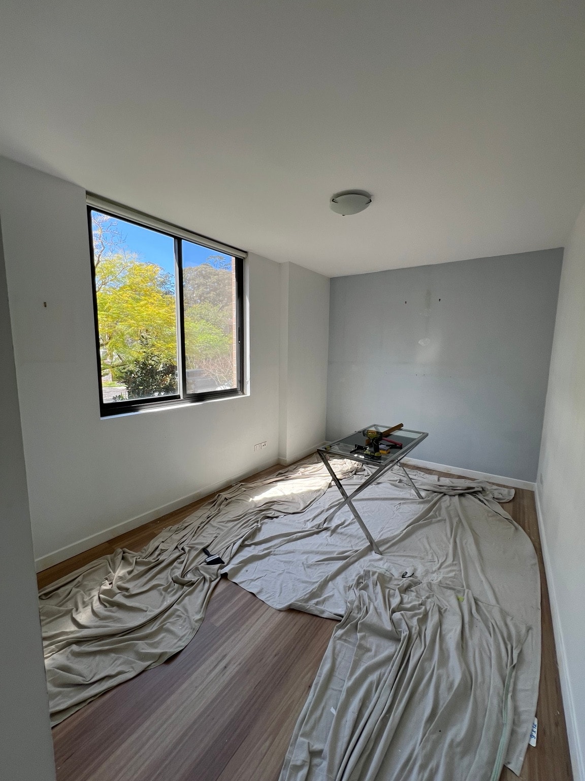 Wahroonga apartment bedroom wall and ceiling finishes beside a black-framed window, before