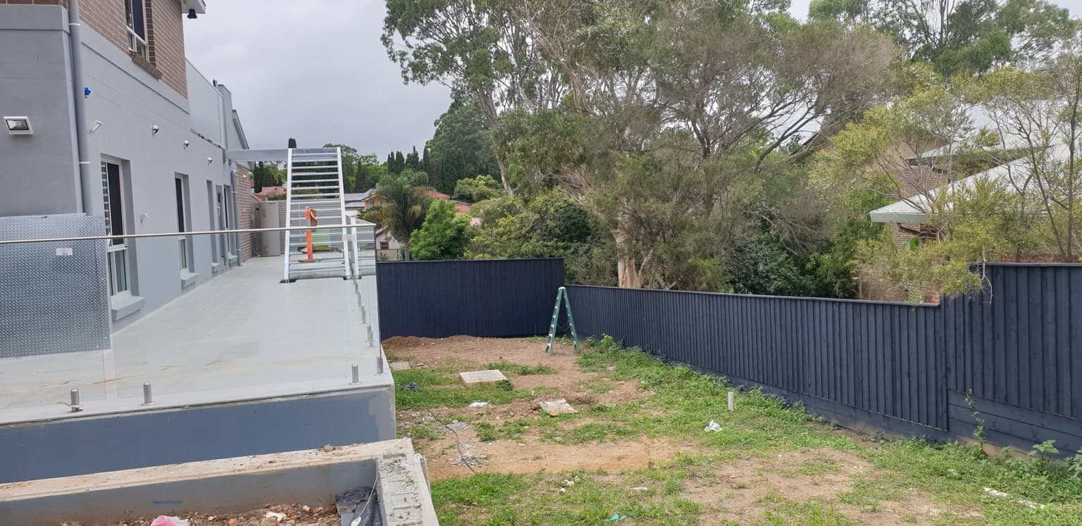 Dark painted timber boundary fence beside the building at Belonging Early Learning in Hornsby, after